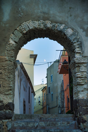 A vertical low angle view of a stone arch of an entrance of the ancient village in Sardiniaの写真素材