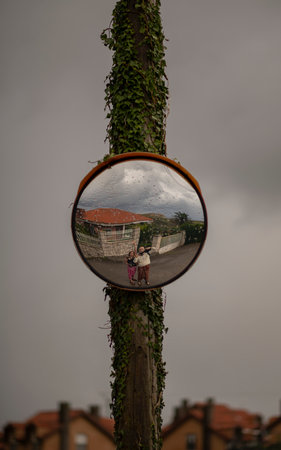 A vertical shot of people reflecting in a mirror on a tree logの写真素材