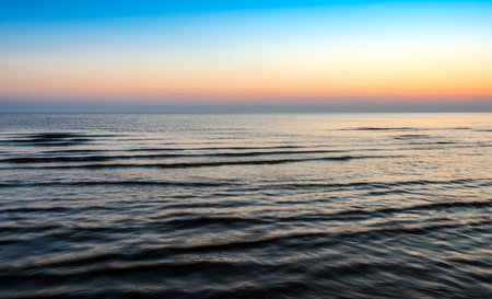 A wide sea with dark blue waves during sunsetの写真素材