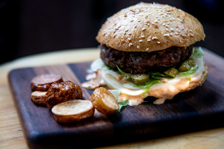 The delicious cheeseburger with crispy bun on a wooden boardの写真素材