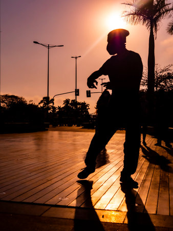 A young person breakdancing in a park during the sunset in the eveningの写真素材