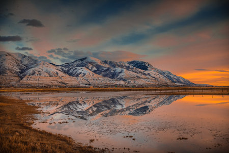 A beautiful view of snowy mountains near a reflective pondの写真素材