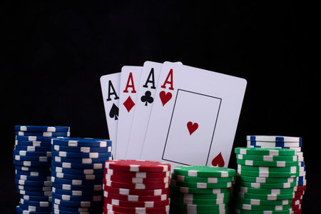 A closeup shot of poker chips and cards on a black background