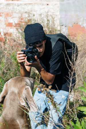 A vertical shot of a photographer taking a photo of a dog.の写真素材
