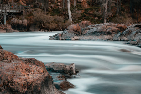 A beautiful view of a river surrounded by rocks in a forestの写真素材