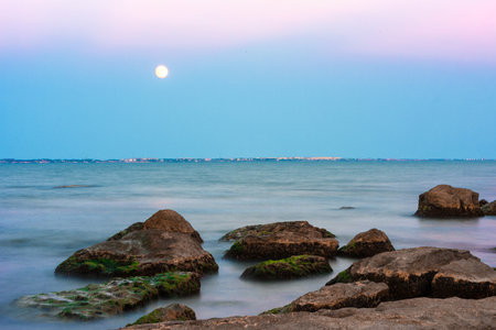 The moon over the sea during sunsetの写真素材