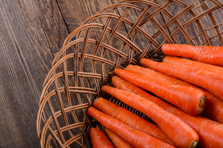 A wicker basket full of fresh carrotsの写真素材