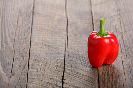 A red bell pepper on a wooden tableの写真素材