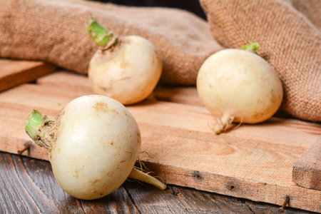 A closeup shot of white turnips on a wooden palletの写真素材