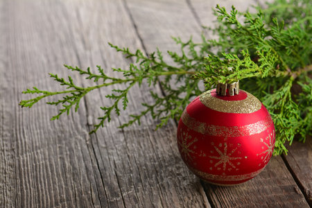 A red ball on a wooden table - holiday decorations, Christmas backgroundの写真素材