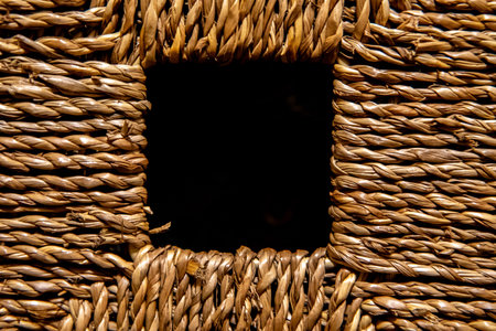 A handle hole on a wicker bin