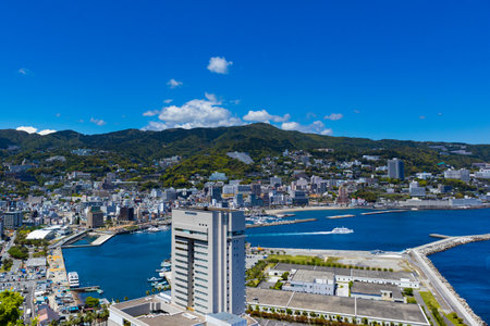 A beautiful view of a cityscape with the ocean and Atami Castle, Atami, Japanの写真素材