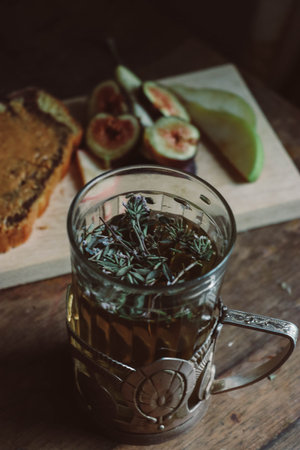 The herb tea near the wooden tray with sliced juicy figs, pear and tasty pie with chocolate creamの写真素材