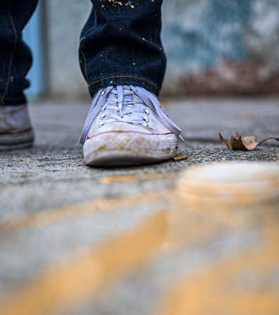 A closeup shot of a person wearing dirty white sport shoesの写真素材