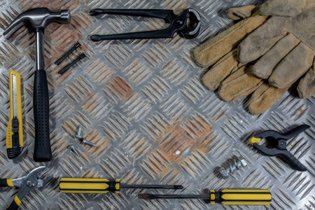 A top view of different tools for construction on the metal surface