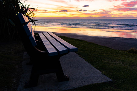 A closeup shot of a single bench outdoors during the sunsetの写真素材