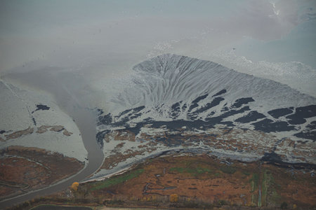 A landscape of a road on hills covered in the snow on a gloomy day in Kamouraska, Quebec, Canadaの写真素材