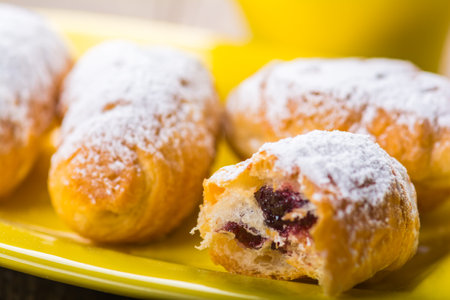 Fresh croissants on a yellow ceramic plate