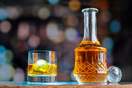 A view of a decanter with whisky and a glass with ice near itの写真素材