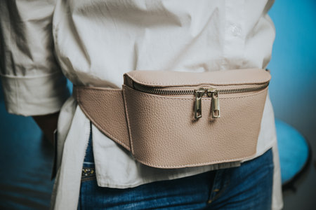 A closeup of a woman wearing a fashionable leather fanny pack