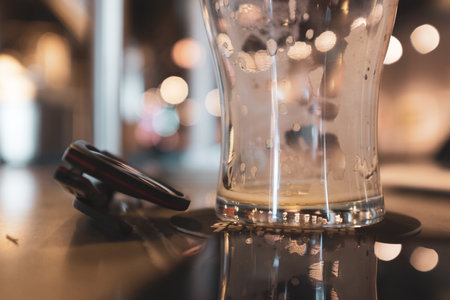 A selective focus of a steamy glass cup and sunglasses on a table with a blurry backgroundの写真素材