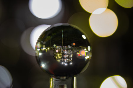 An illuminated factory building reflecting on a crystal ball