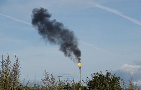 A Smoke and flames from an industrial chimney polluting the air.の写真素材