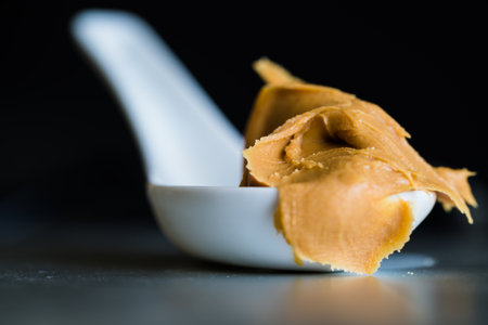 A closeup shot with a spoon of delicious ice cream on black background.