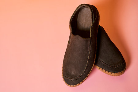 A closeup shot of a pair of male shoes on a pink backgroundの写真素材
