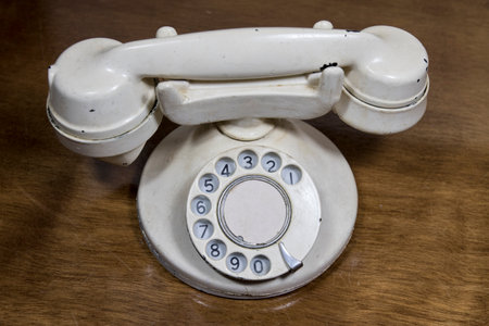 A top view of the white vintage telephone on a wooden tableの写真素材