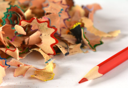 Bright colorful pencils with sharpening shavings on the white paper or tableの写真素材