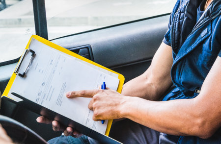 A worker shows something on paper in a carの写真素材