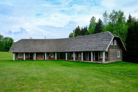 A wooden house in a green field in Lithuaniaの写真素材