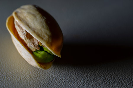 A closeup shot of a single pistachio isolated on a gray backgroundの写真素材