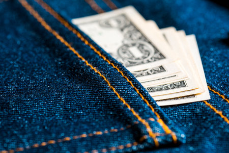 A bunch of US dollar banknotes in a jeans pocketの写真素材