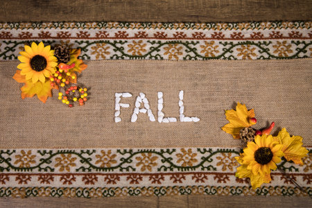 A top view of the Fal word and artificial flowers on embroidered linen fabricの写真素材