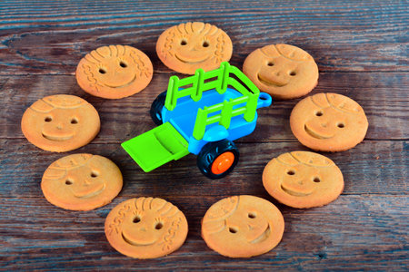 A toy car surrounded by smiling cookiesの写真素材