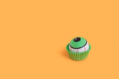 A creepy human eyeball candy to celebrate Halloween against an orange backgroundの写真素材