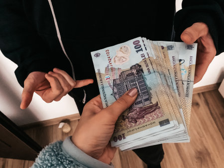 A closeup of a female hand lending money to a manの写真素材