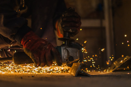 A Caucasian male with a working uniform from Spain welding metal in construction site