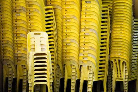 The stacks of yellow plastic chairsの写真素材