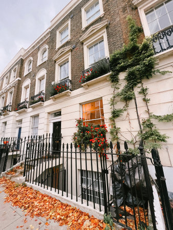 A white building with green plants and red flowers in the streets of London, UKの写真素材