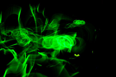 An abstract background of neon green lights on a black surfaceの写真素材