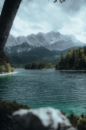A vertical shot of a coast surrounded by mountains and forestsの写真素材