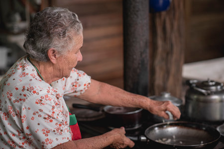 An old Hispanic woman cooking corn tortillas typical for Costa Rica in Tilaran, Guanacaste, Costa Ricaの写真素材