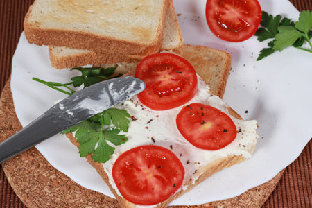 A closeup of sandwiches with toast bread, tomatoes, cheese, and parsley.の写真素材