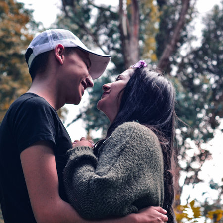 A happy couple posing in a forest during the dayの写真素材