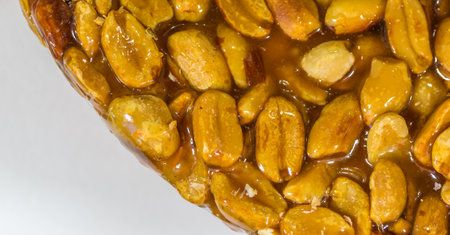 A closeup of peanut candy with transparent sweet honey on a white backgroundの写真素材