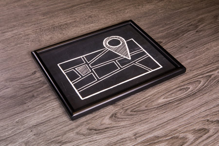 A location map on chalkboard, blackboard over a gray wood backgroundの写真素材