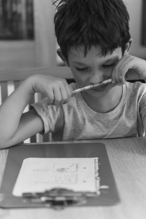 A closeup of a boy adding crosses on the paperの写真素材